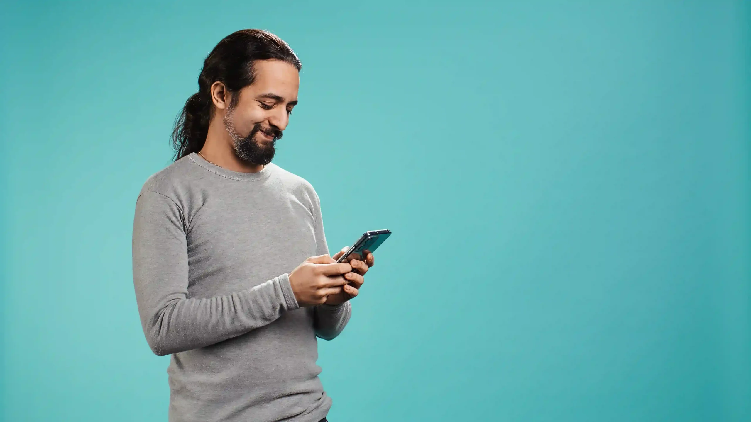 Man smiling while using smartphone to make an appointment online